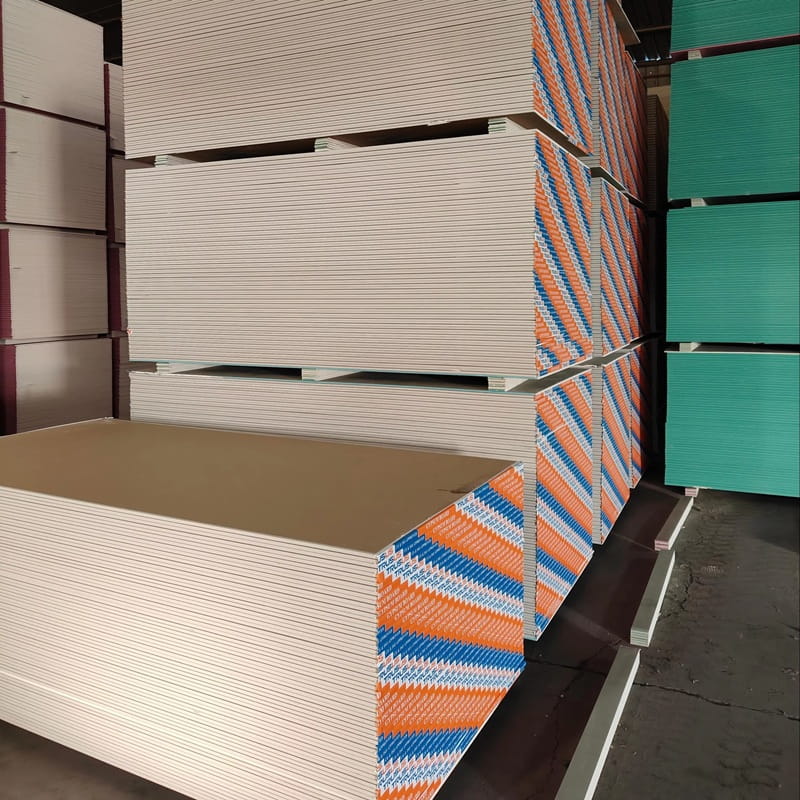 Stacked drywall sheets in pink and orange, ideal for construction and home renovations.